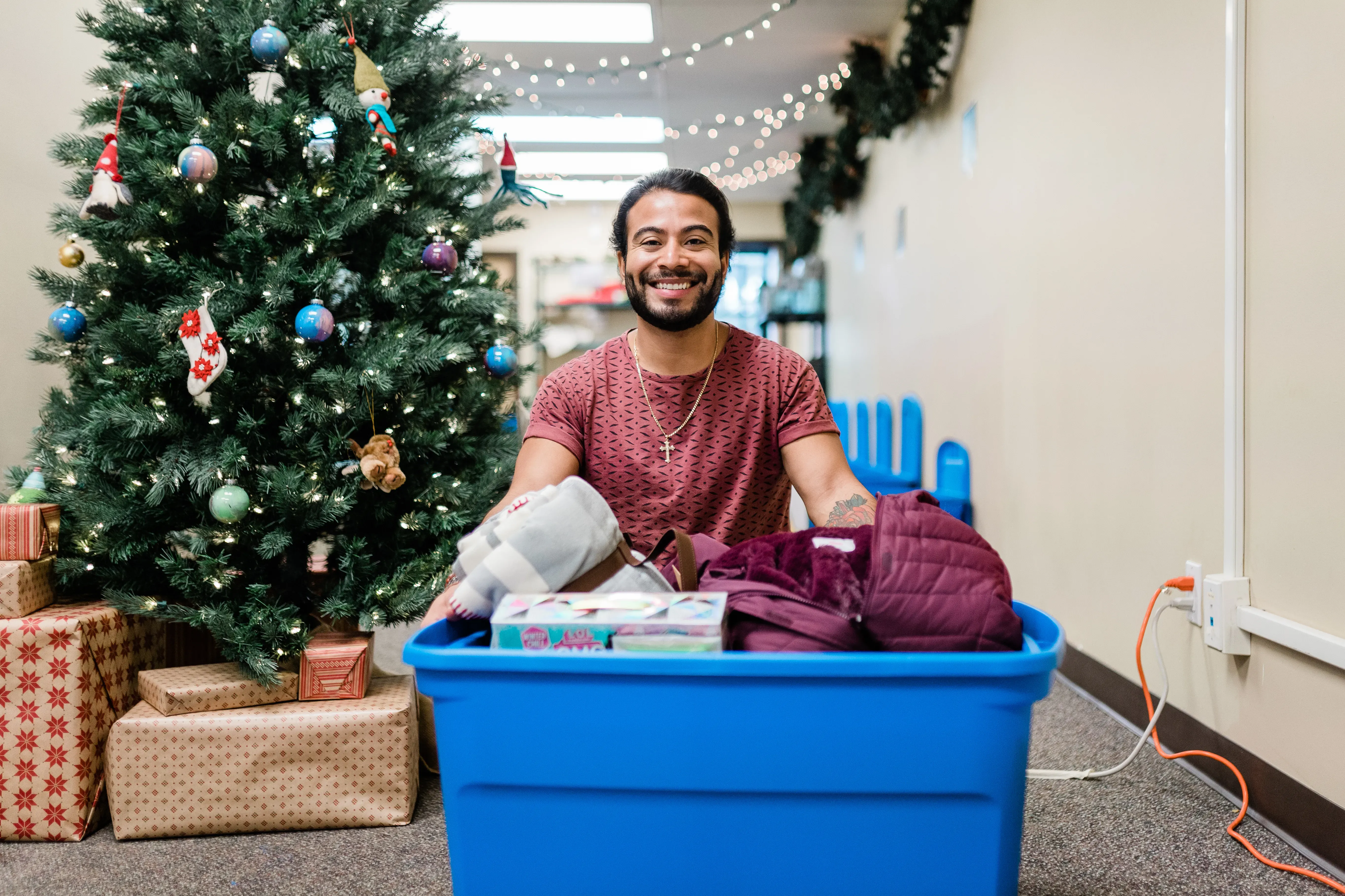 Outreach Worker Joshua filling a Christmas Hamper with winter clothes, household necessities, and toys