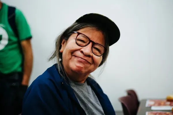 Community member smiling at UGM's Thanksgiving Meal. 