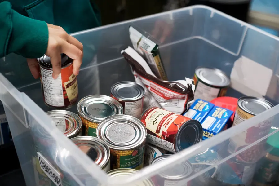 UGM staff filling a food hamper with essential food items.